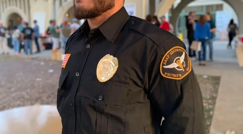 Professional bilingual security guard in uniform at a commercial building entrance